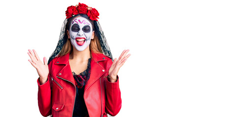 Woman wearing day of the dead costume over background celebrating mad and crazy for success with arms raised and closed eyes screaming excited. winner concept