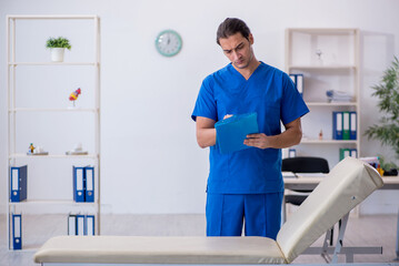 Fototapeta premium Young male doctor taking notes at the hospital