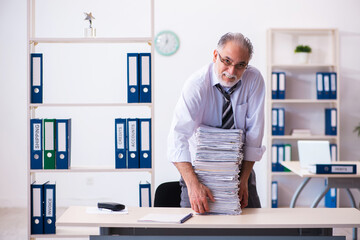 Old male employee unhappy with excessive work in the office