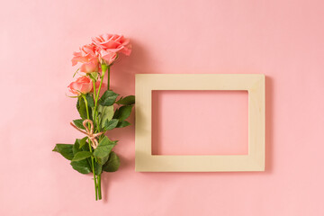 wooden photo frame next to bunch of roses