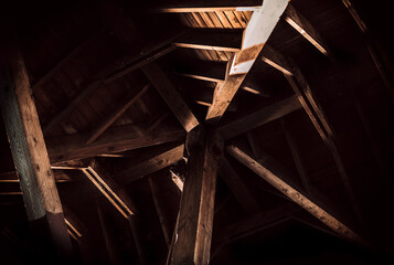 Timber roof truss with beautiful interplay of light and shadows. Areas with bright sun and deep...