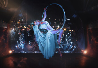 Elven Girl in long dress posing on the flying hoop, magical treatment creates a fairy tale look
