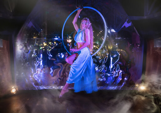 Elven Girl in long dress posing on the flying hoop, magical treatment creates a fairy tale look