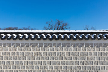 Naklejka premium Winter in Korea. White snow is covered over beautiful traditional stone walls.