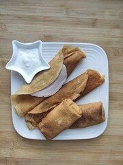 Pancakes with a sour cream on wooden table,