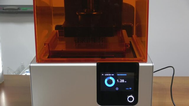 Stereolithography DPL 3d printer create detail and liquid drips.  Additive 3d printer in work, create scaled model by UV polymerization. 
