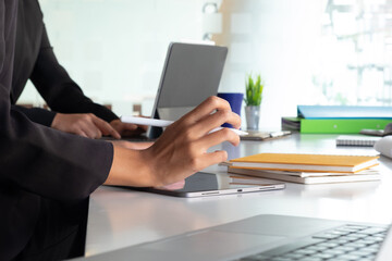 Cropped shot of two UI developers meeting on their project with paperwork and tablet on meeting...