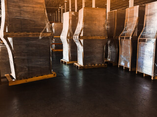 Worker driving forklift loading shipment carton boxes goods on wooden pallet at loading dock from container truck to warehouse cargo storage in freight logistics, transportation industrial, delivery