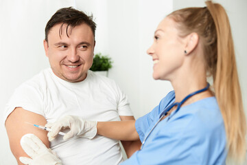 Obraz premium male patient next to doctor woman injection health covid vaccination