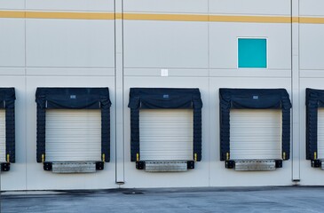 Loading dock doors at the back of a generic warehouse in an industrial district.