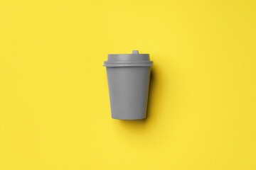 Disposable coffee cup in yellow gray colors