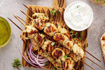 Greek chicken souvlaki on wooden skewers with tzatziki sauce