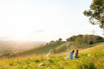 Happy family: mother, father and children son on nature on sunset