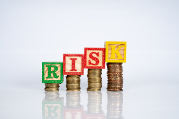 wooden cube and letter "RISK" with financial concept.