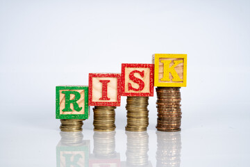 wooden cube and letter "RISK" with financial concept.