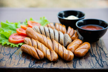 Fried sausages recipe with fresh tomato and sauces ketchup ready to be served, international food style concept
