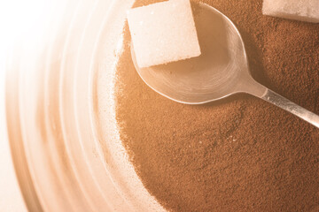 Glass cup with dry coffee and sugar pieces. Close up photo.