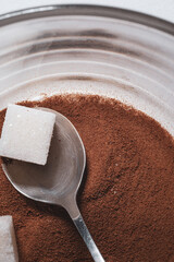 Glass cup with dry coffee and sugar pieces. Close up photo.