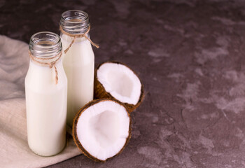 Obraz na płótnie Canvas Coconut milk in bottles on gray background.Copy space.