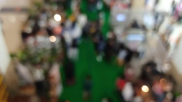 blurred bokeh defocused background of center hall expo exhibition hall  inside Interior of a mall with people walking by