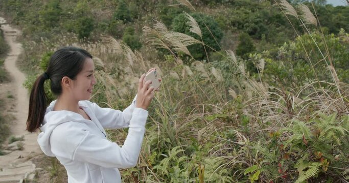 Woman go hiking and use cellphone to take photo