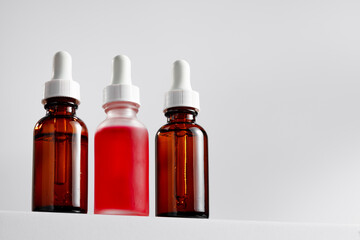 Essential oil bottle on gray block against gray background