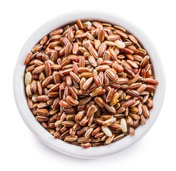 Brown rice - whole grain rice with outer hull or husk in ceramic bowl on white background.