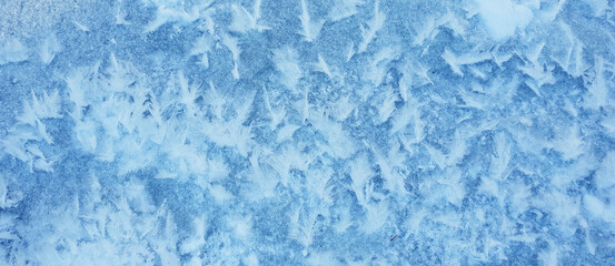 Obraz premium Snow crystals form beautiful snow pattern on frozen icy river. Snowflake background.