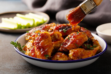 Sweet and spicy chicken wings with glaze served with celery sticks and ranch dressing