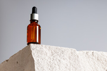Glass bottle with cosmetic oil on cinder block