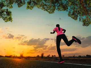 Young woman is running and jogging an outdoor workout on the road in the morning for lifestyle health.