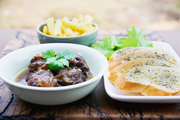 Beef stew serve with French fries and garlic bread