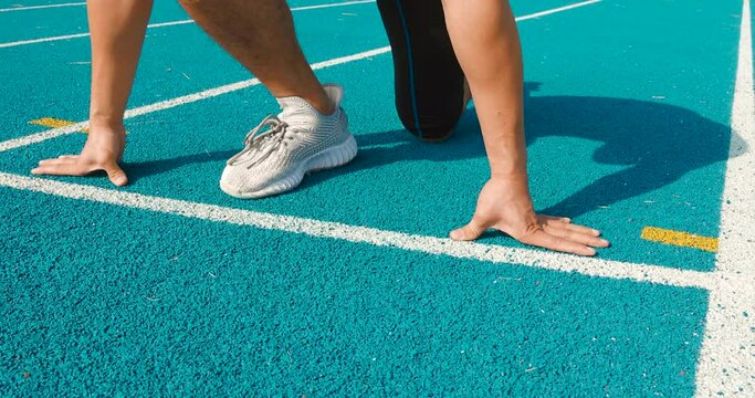 young muscular athlete Hands on starting line