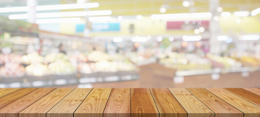 Wood table top with supermarket grocery store blurred background with bokeh light for product...