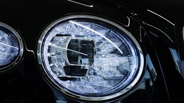 Luxury car front LED headlight with crystal effect. Closeup cinematic 4k shot.