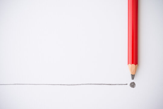 Flat lay of red colour pencil write line and end point on white paper background copy space. Business conclusion, creative idea, imagination and education concept.