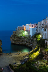 Fototapeta na wymiar イタリア　ポリニャーノ・ア・マーレの夕暮れ時のカラ・ポルト海岸と断崖の上の旧市街