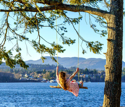 Girl swinging on tree at the ocean - Whiffen Spit, Sooke, British Columbia, Canada 