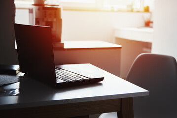 Freelancer home workplace. Laptop on table in office interior. Online job and remote work.