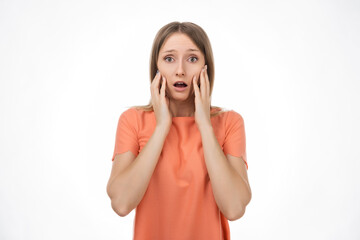 Worried and concerned blond girl is looking with frightened expression. Studio shot, white background