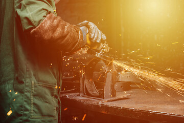 Closeup image of angle grinder at work, yellow tracks from sparks flying away in the process. 