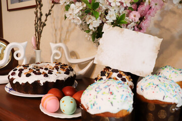 waiting for the Easter holiday. festive atmosphere in the house. spring flowers, Easter cake and Easter eggs on a wooden table in the room