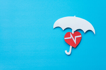 Health or life insurance and hospital concept. Paper cutout of white umbrella and red heart pulse on blue background. Insurance business is future investment and life planning.