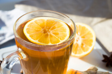 Hot Ginger tea in glass mug with lemon, honey and spices at white. Healing tea. Top view with copy space.