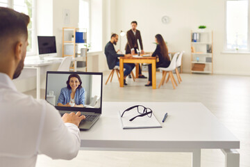 Office worker making video call on laptop and talking to colleague, client or online business coach