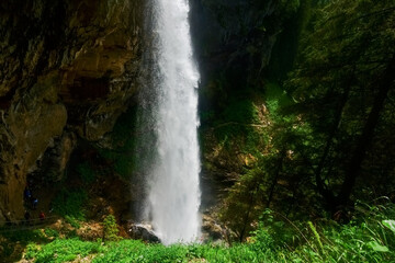 wonderful high waterfall over a cliff in the mountains