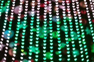 Color Bokeh on a dark background with hearts for use in graphic design