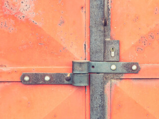 Warehouse door. Detail of red industrial door with barrel lock housing