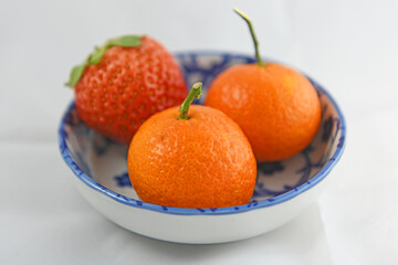 Organic farm fresh Strawberry and Mandarin Orange on a Chinese porcelain bowl at breakfast