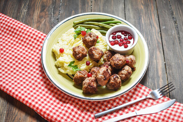 Swedish meatballs with mashed potatoes and green beans on wooden background